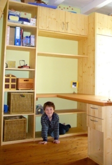 Kinderzimmer mit Regalwand und Schreibtisch