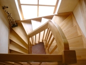 Blick von oben auf eine gewendelte Holztreppe