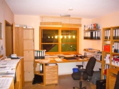Arbeitszimmer mit Schreibtisch und Regalen aus Holz