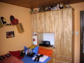 Jugendzimmer mit Bett und Schrank aus Holz