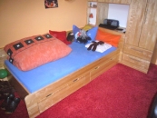 Jugendzimmer mit Bett und Schrank aus Holz