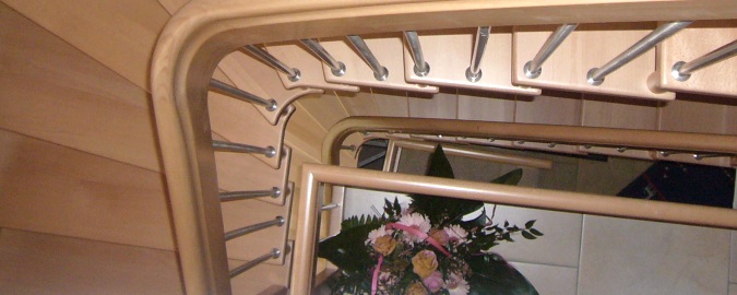 Blick von oben in ein Treppenhaus mit Holztreppe